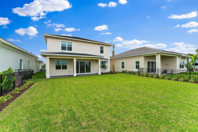 a living room with furniture large windows and wooden floor