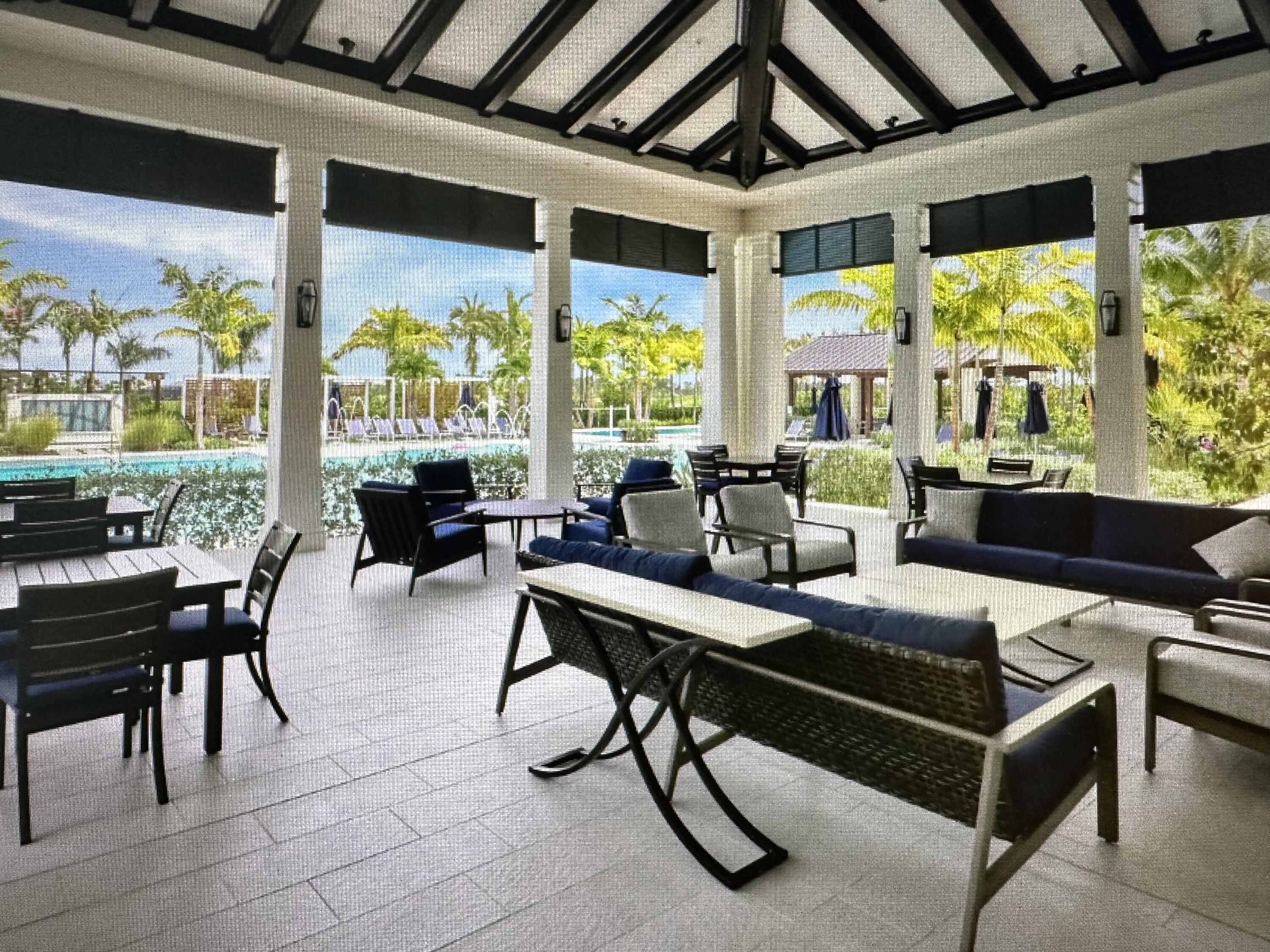 12622 Nautilus Circle Palm Beach Gardens, FL 33412 - Photo 58 of 66 a living room with furniture tv and large windows