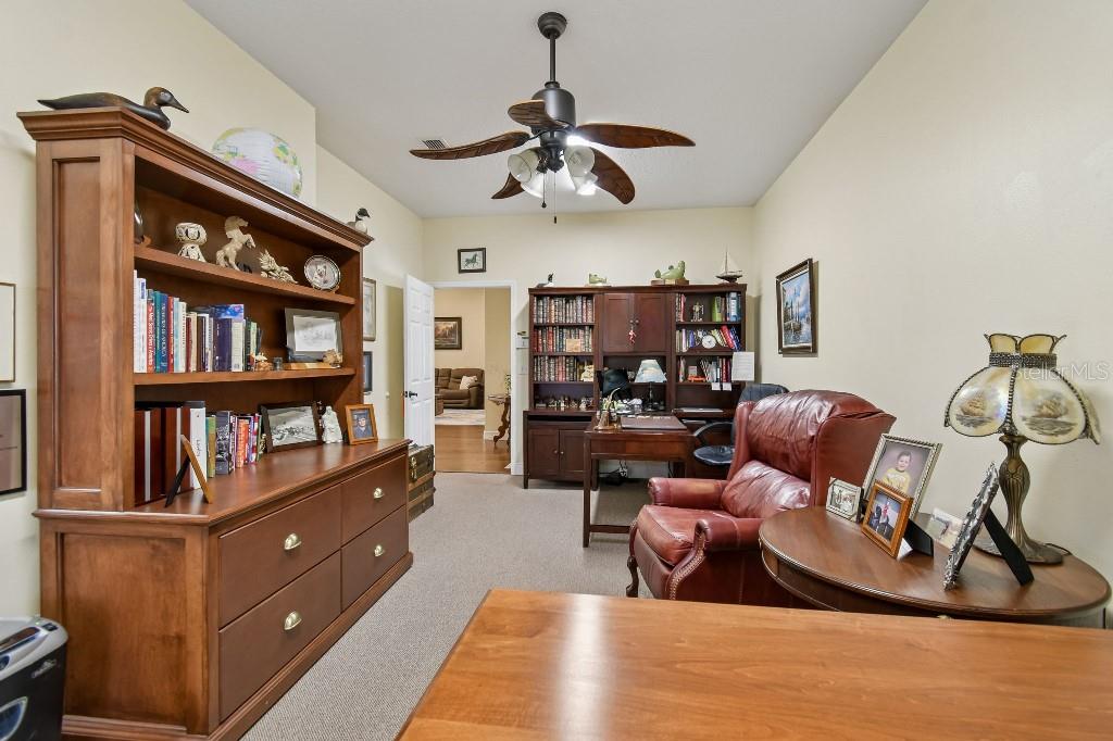 3302 Jap Tucker Road Plant City, FL 33566 - Photo 12 of 44 a living room with furniture a rug and a book shelf