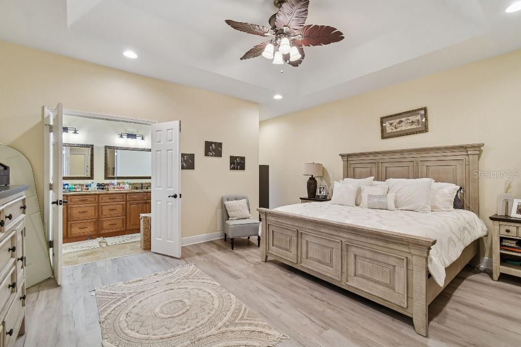 3302 Jap Tucker Road Plant City, FL 33566 - Photo 24 of 44 a spacious bedroom with a bed and a chandelier