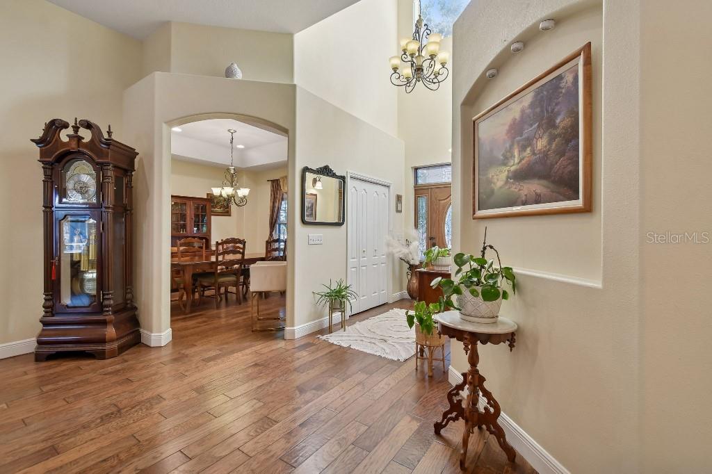 3302 Jap Tucker Road Plant City, FL 33566 - Photo 5 of 44 a view of a hallway with wooden floor and a chandelier