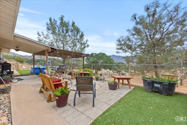 a view of a patio with table and chairs potted plants with wooden fence