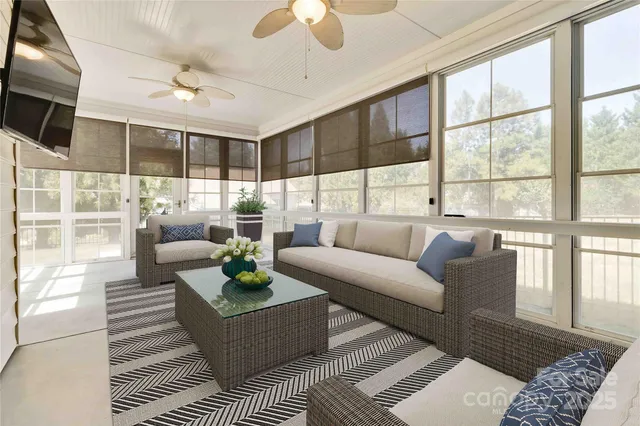 a living room with furniture a flat screen tv and a floor to ceiling window