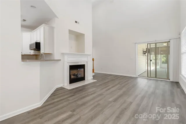 a view of empty room with wooden floor and fireplace