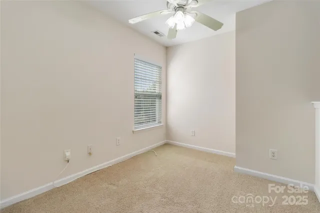 an empty room with a window and a ceiling fan