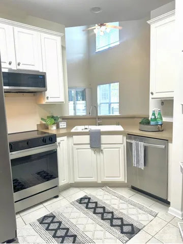 a kitchen with granite countertop a stove a sink and a microwave