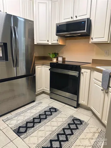 a kitchen with stainless steel appliances kitchen island granite countertop a refrigerator stove and microwave