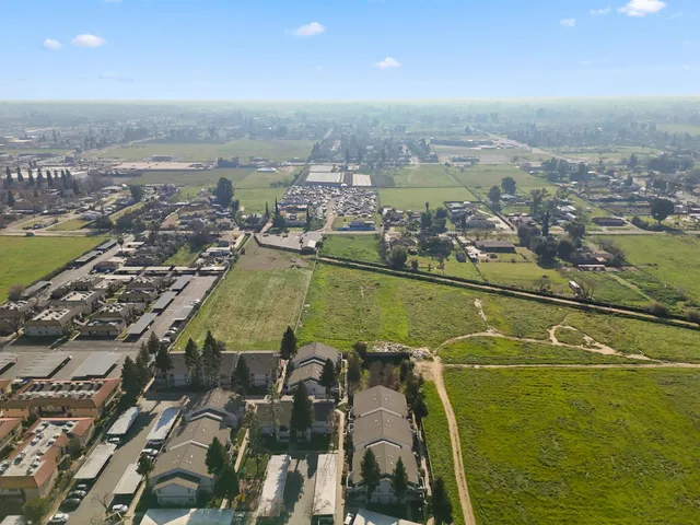 an aerial view of a city with lots of residential buildings and ocean view in back