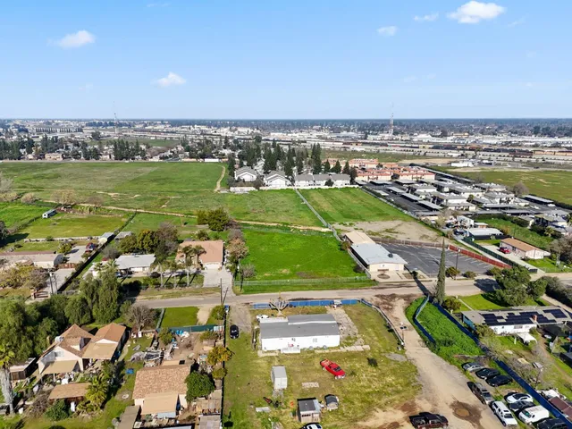 an aerial view of a city with lots of residential buildings ocean and mountain view in back