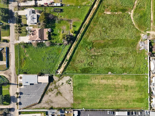 an aerial view of a city with lots of residential buildings and ocean view in back
