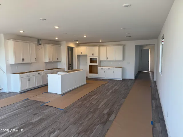 a large kitchen with cabinets a sink and dishwasher a stove with wooden floor