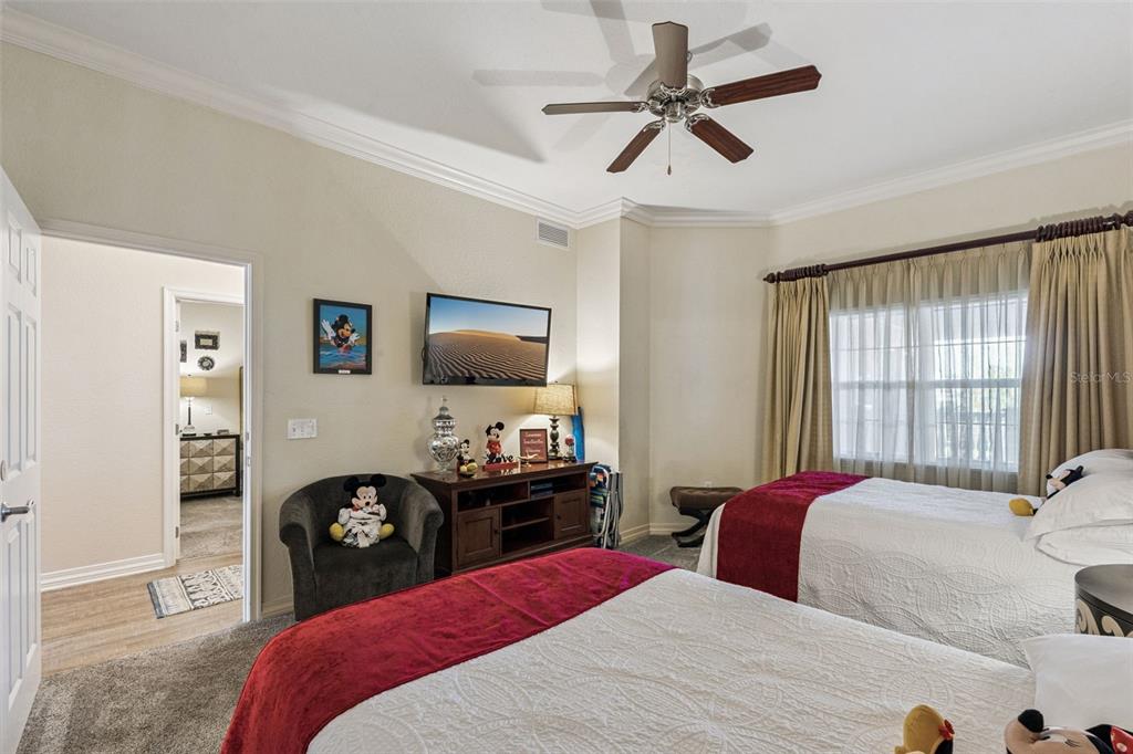 7656 Whisper Way, Unit 402 Reunion, FL 34747 - Photo 22 of 57 a bedroom with a bed dresser and a window