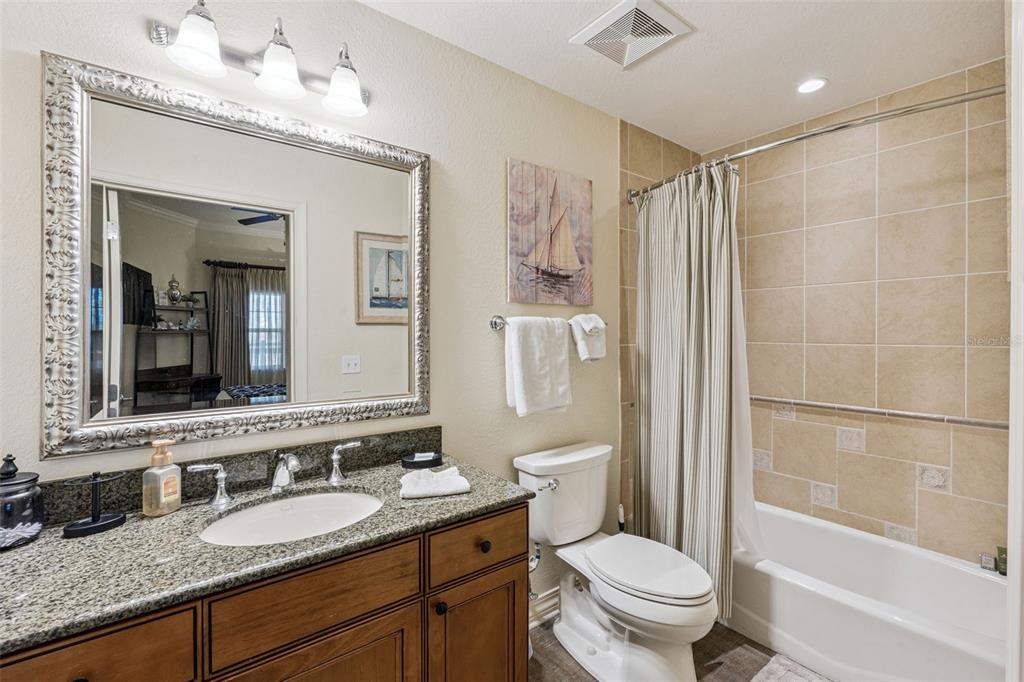 7656 Whisper Way, Unit 402 Reunion, FL 34747 - Photo 23 of 57 a bathroom with a granite countertop sink toilet and shower