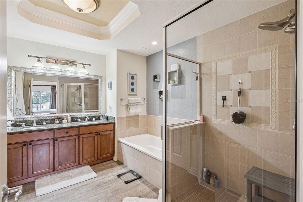 7656 Whisper Way, Unit 402 Reunion, FL 34747 - Photo 26 of 57 a large bathroom with a tub shower sink and mirror