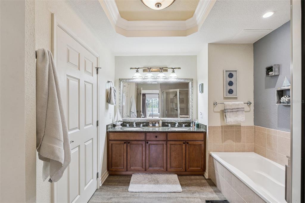 7656 Whisper Way, Unit 402 Reunion, FL 34747 - Photo 27 of 57 a bathroom with a tub sink and mirror