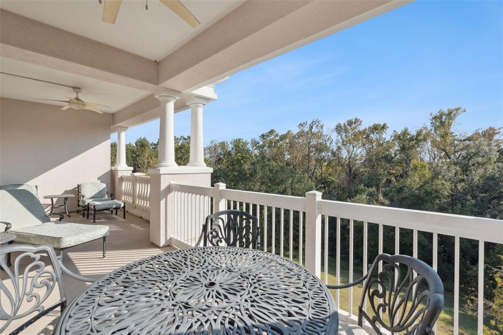 7656 Whisper Way, Unit 402 Reunion, FL 34747 - Photo 32 of 57 a balcony with wooden floor and outdoor seating