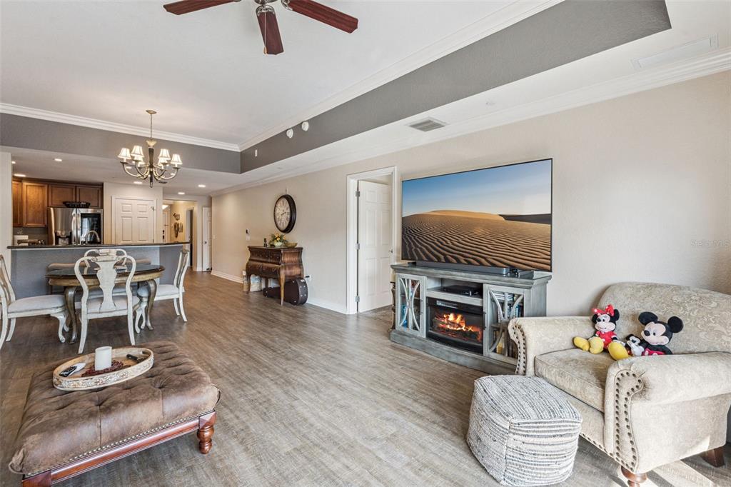 7656 Whisper Way, Unit 402 Reunion, FL 34747 - Photo 5 of 57 a living room with furniture and a flat screen tv with wooden floor