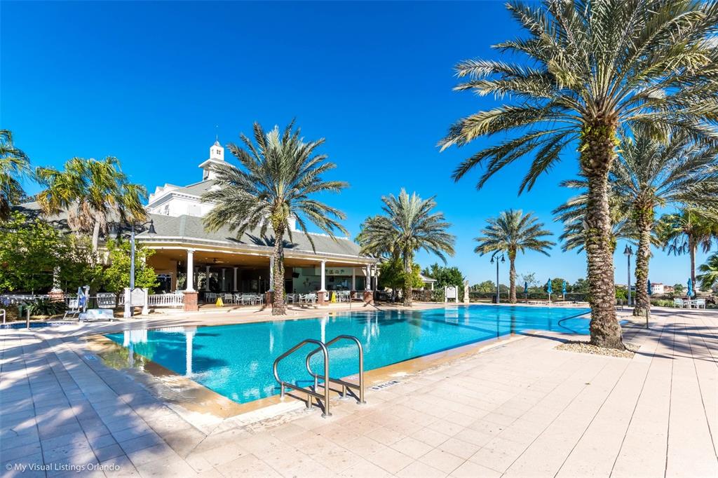 7656 Whisper Way, Unit 402 Reunion, FL 34747 - Photo 56 of 57 a view of a swimming pool with a lawn chairs under palm trees