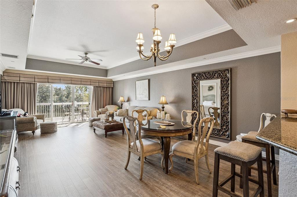7656 Whisper Way, Unit 402 Reunion, FL 34747 - Photo 10 of 57 a living room with furniture a chandelier and a large window