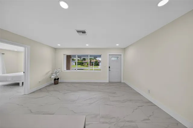 a large kitchen with stainless steel appliances kitchen island a large counter top a stove a chimney a sink and a refrigerator