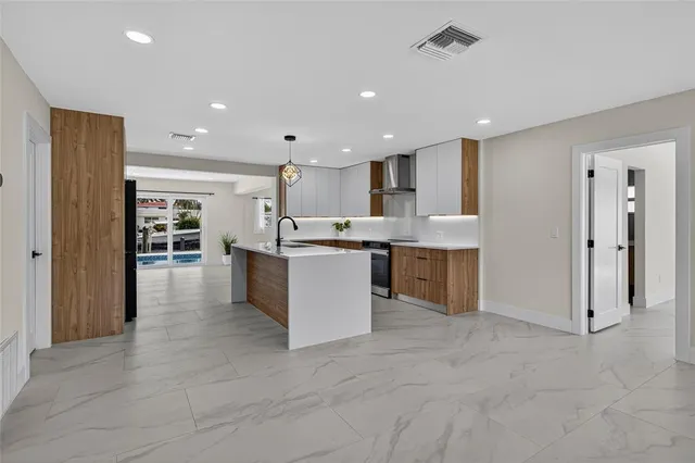 a kitchen with kitchen island granite countertop a sink counter top space appliances and cabinets