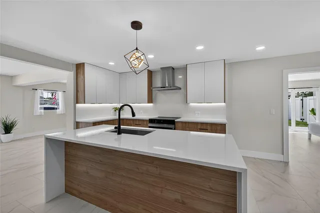 a kitchen with kitchen island granite countertop a sink stainless steel appliances and white cabinets