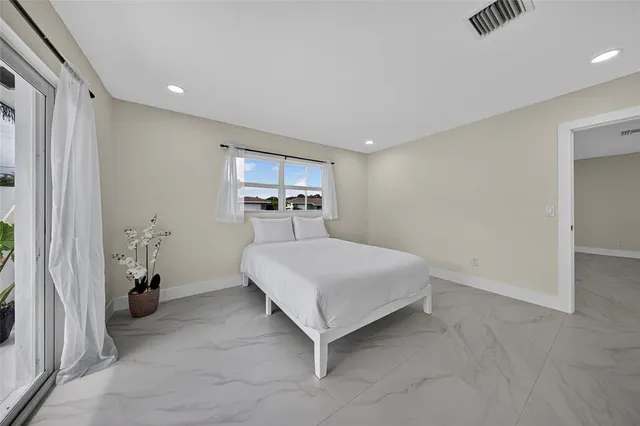 a bedroom with a large bed and a window