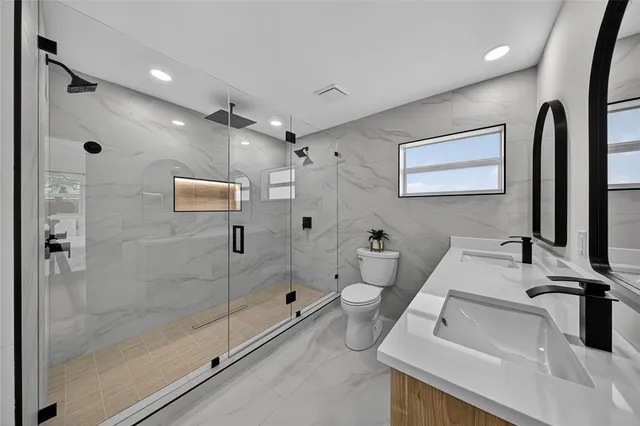 a large kitchen with stainless steel appliances a sink a stove and a refrigerator