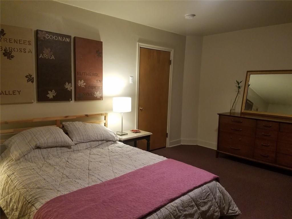 3235 Parkview Avenue Pittsburgh, PA 15213 - Photo 15 of 21 a bedroom with a bed and a flat tv screen on dresser