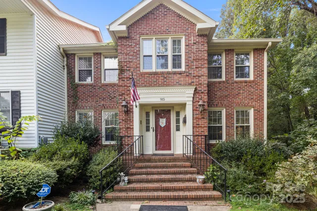 a front view of a house with plants and garden