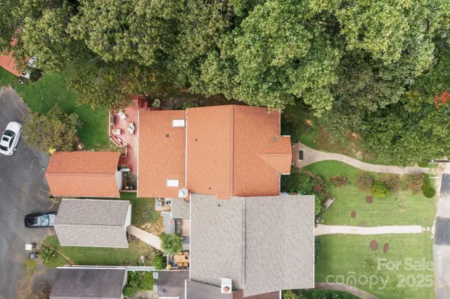 an aerial view of residential houses with outdoor space and trees