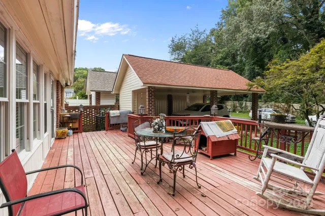 a view of a patio with table and chairs under an umbrella with wooden floor