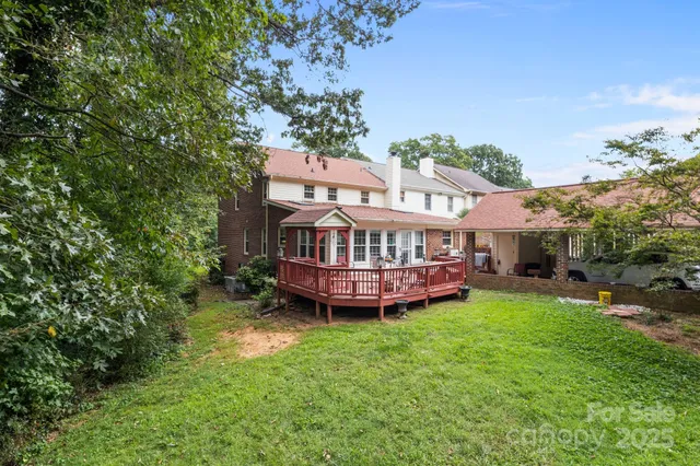 a view of a house with a big yard plants and large trees