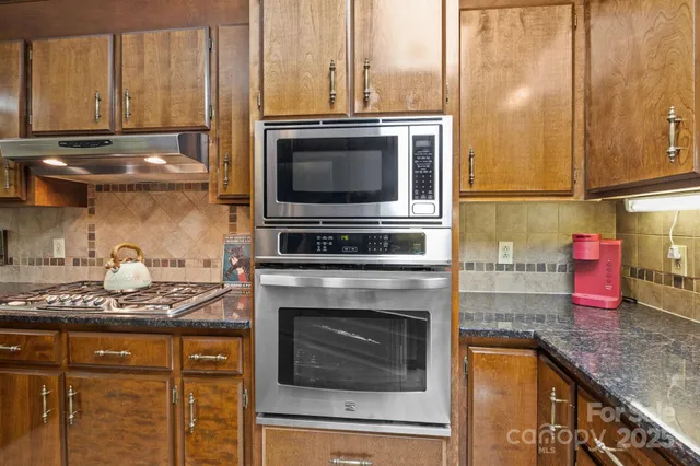 a kitchen with stainless steel appliances granite countertop a refrigerator and a sink