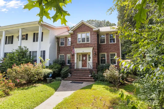 a front view of a house with yard and green space