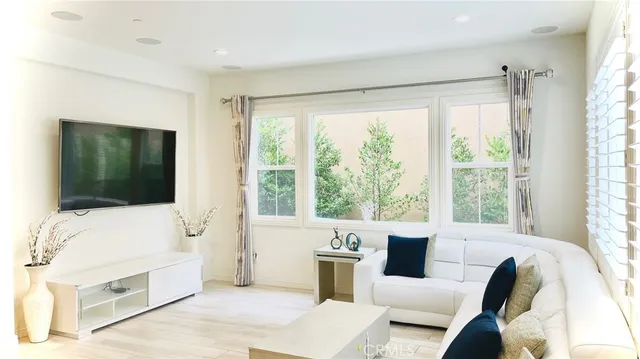 a kitchen with stainless steel appliances kitchen island granite countertop a refrigerator a stove a sink dishwasher and white cabinets with wooden floor