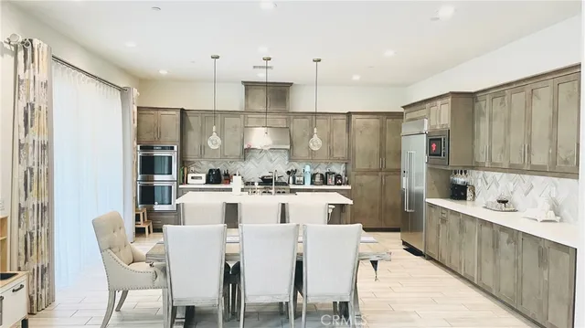 a kitchen with stainless steel appliances granite countertop a sink a stove and refrigerator