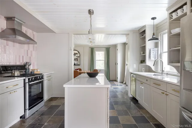 a kitchen with sink stove and refrigerator