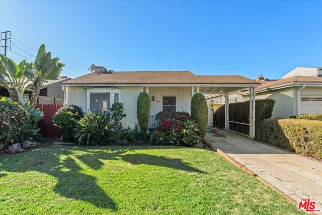 a front view of a house with a yard and potted plants