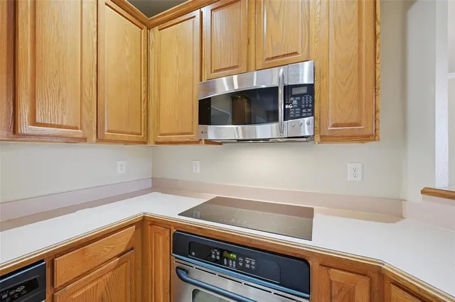 a kitchen with stainless steel appliances granite countertop white cabinets and a microwave oven