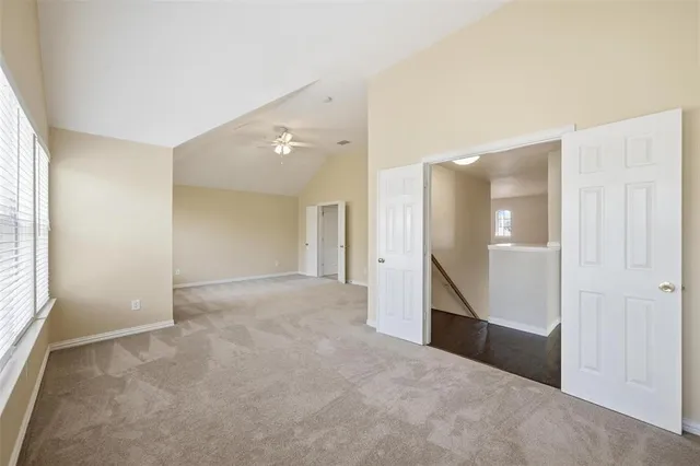 an empty room with windows and entrance to other room