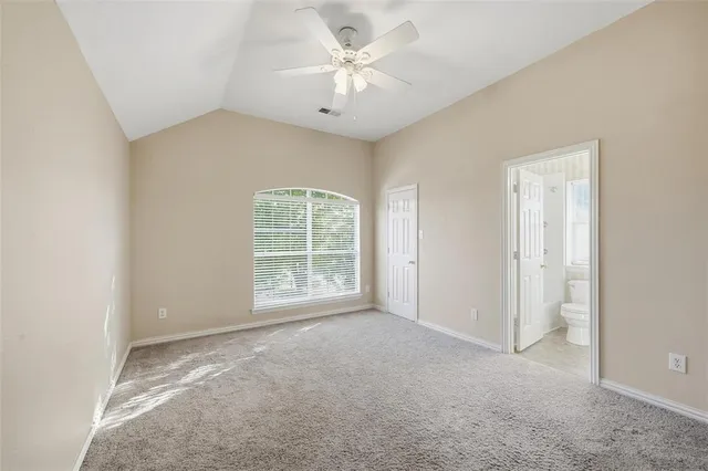 an empty room with a ceiling fan and a window