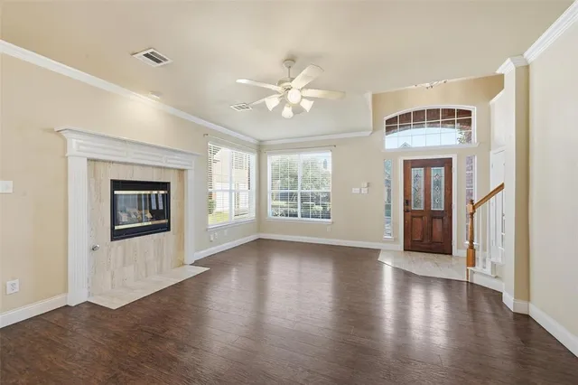 a view of an empty room with window and wooden floor
