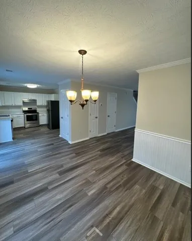 a view of a room with wooden floor and a ceiling fan