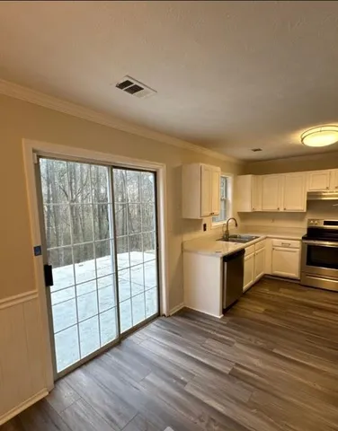 a large kitchen with a large window a sink and stainless steel appliances