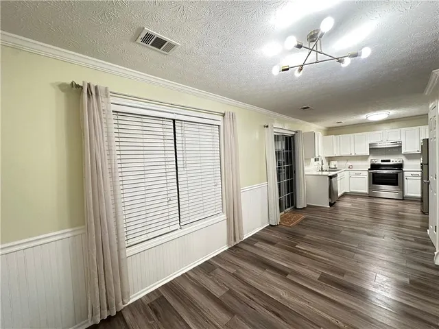 a view of a kitchen with a stove cabinets wooden floor and a kitchen