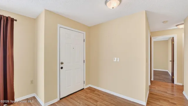 a kitchen with a refrigerator and a wooden floor