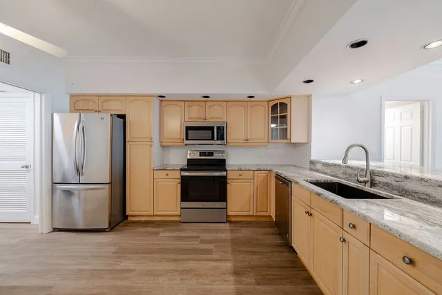 a kitchen with granite countertop a refrigerator stove and sink
