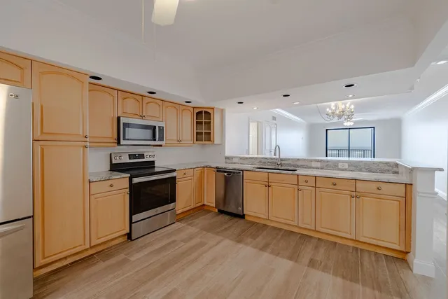 a kitchen with granite countertop a refrigerator stove top oven and sink