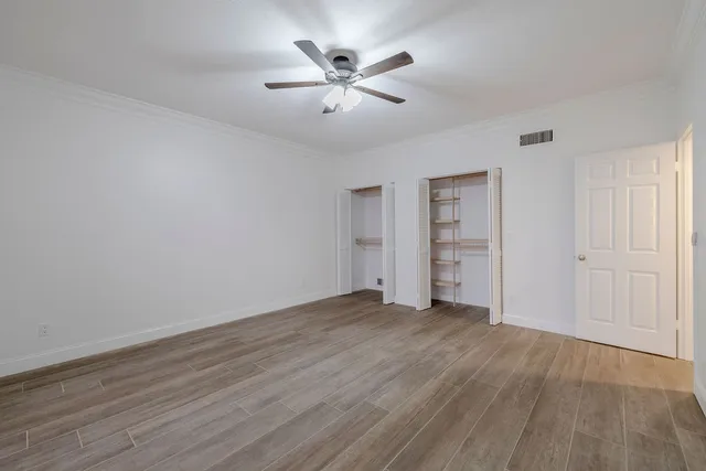 an empty room with closet and windows